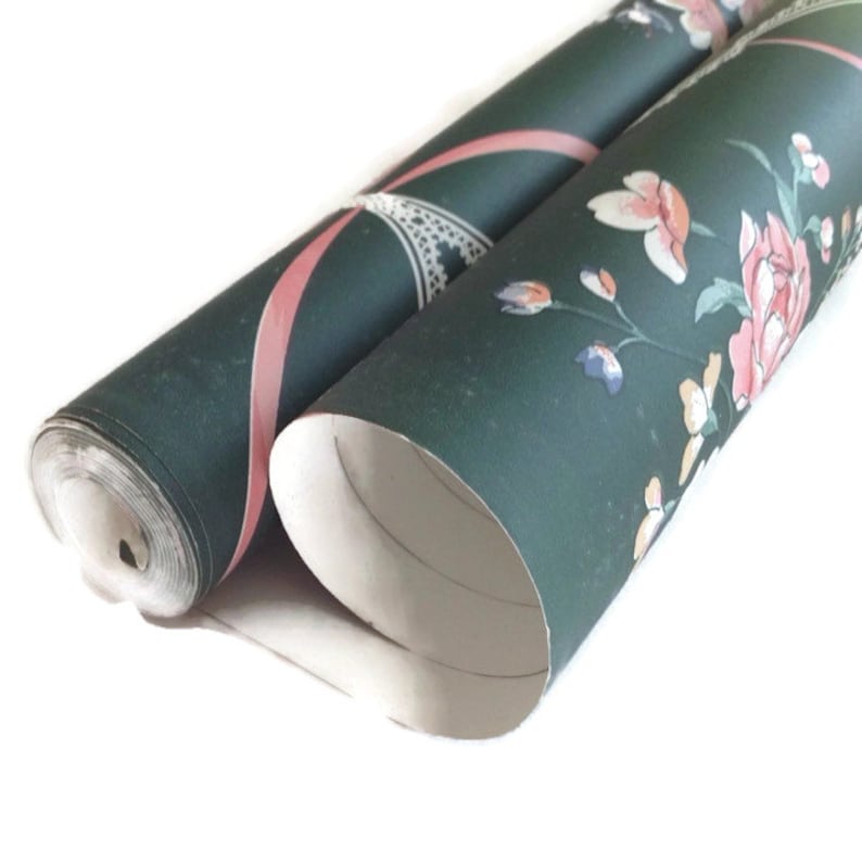 Puede incluir: Dos rollos de papel tapiz verde con una cinta rosa y un patr&oacute;n floral. El papel tapiz tiene un fondo blanco con flores rosas, blancas y amarillas.