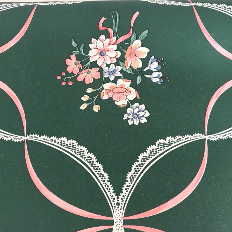 Puede incluir: Papel tapiz verde con un patr&oacute;n floral rosa y blanco. Las flores est&aacute;n dispuestas en un ramo y est&aacute;n rodeadas por un dise&ntilde;o de encaje blanco. El fondo es de color verde oscuro.
