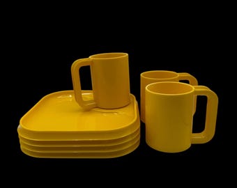 May include: A set of four yellow plastic mugs with handles and four yellow plastic square plates stacked on top of each other.
