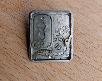 Broche rectangular estilo Steampunk con engranajes: piezas de reloj recicladas, metal plateado con cerradura.