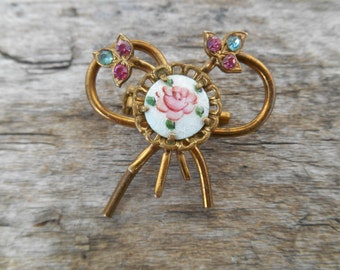 Broche vintage de rosa esmaltada con lazo, detalles de diamantes de imitación, tono dorado, delicado.