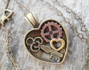 Collar con medallón en forma de corazón estilo Steampunk con engranaje, llave y corazón en una cadena de corazones.