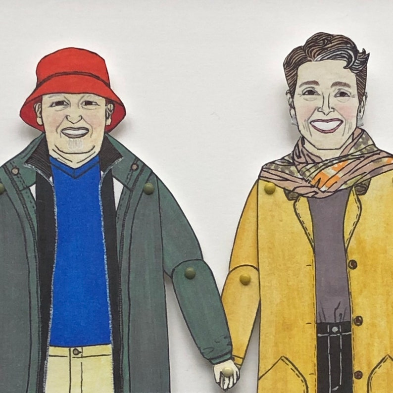 May include: Two paper dolls, one wearing a red hat and a green jacket, the other wearing a yellow jacket with a patterned scarf.