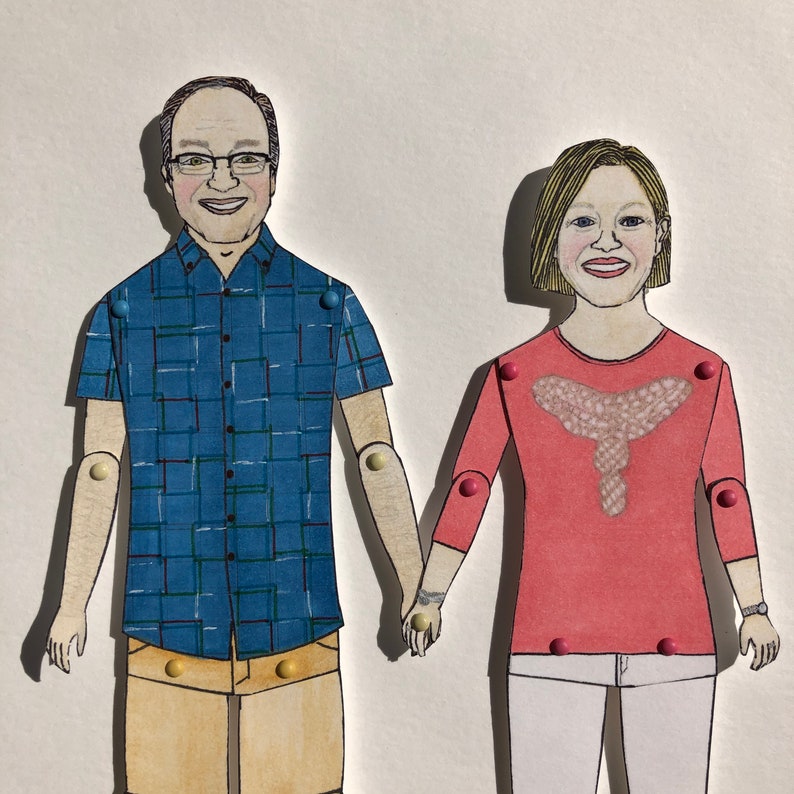 May include: A paper doll couple, a man wearing a blue plaid shirt and khaki shorts, and a woman wearing a red sweater with a white design and white pants.