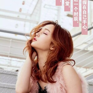 May include: A woman with long, wavy, auburn hair wearing a black lace dress and a pink fur vest. She is sitting on a set of stairs with her eyes closed and her head tilted back.