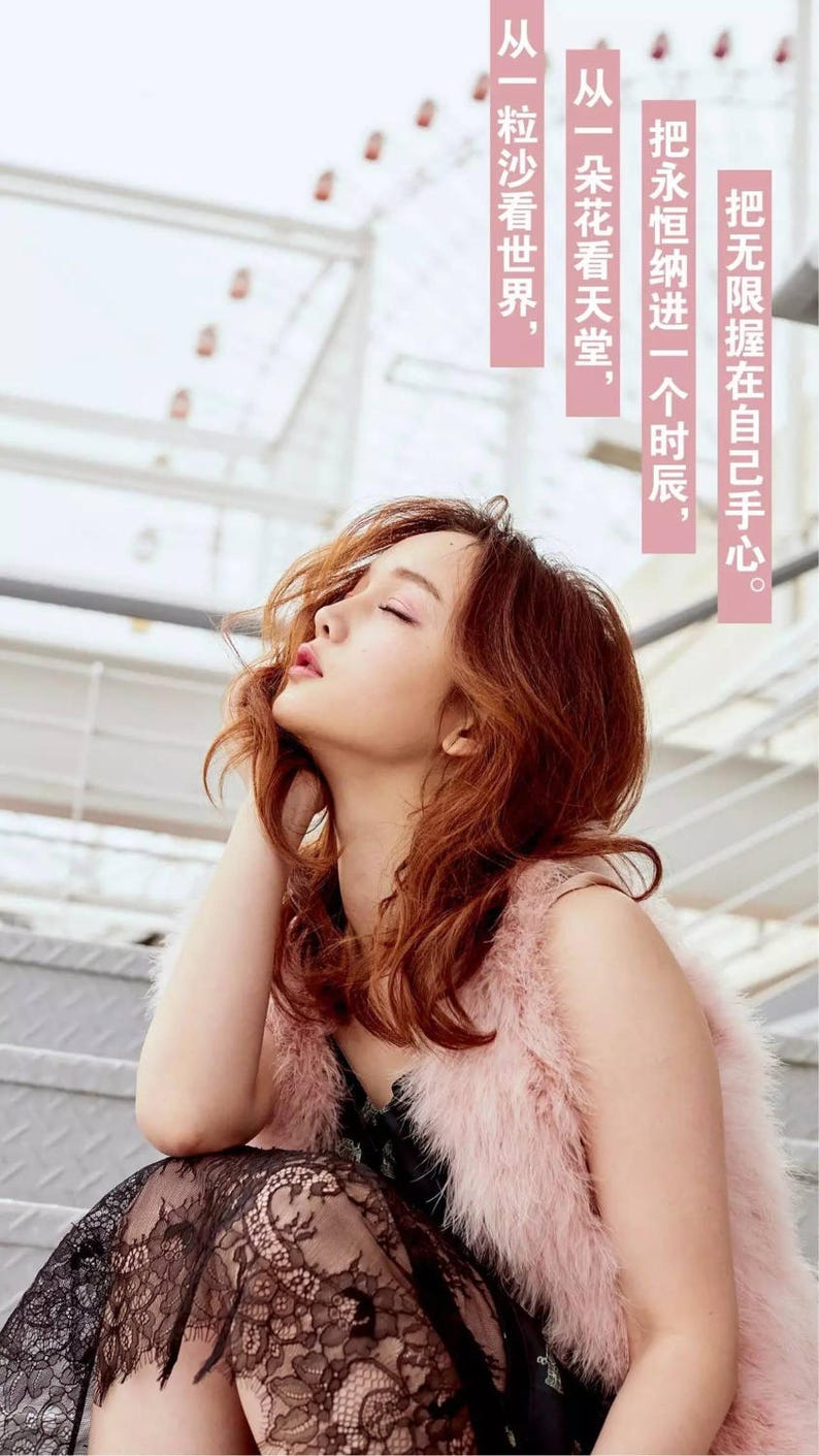 May include: A woman with long, wavy, auburn hair wearing a black lace dress and a pink fur vest. She is sitting on a set of stairs with her eyes closed and her head tilted back.