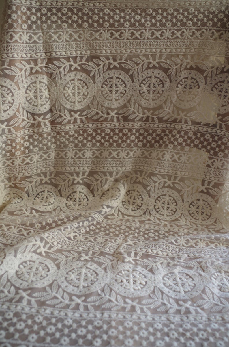 Peut inclure: Tissu de dentelle blanche avec un motif floral d&eacute;licat. Le tissu a une texture transparente et est parfait pour les projets de couture ou d'artisanat.