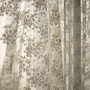 Puede incluir: Cortinas blancas y transparentes con un delicado patr&oacute;n floral de color marr&oacute;n.