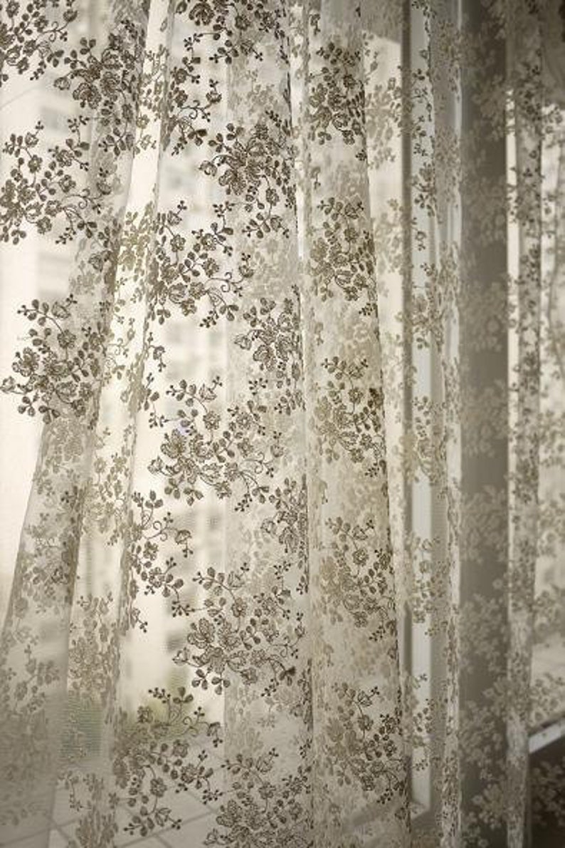 Puede incluir: Cortinas blancas y transparentes con un delicado patr&oacute;n floral de color marr&oacute;n.