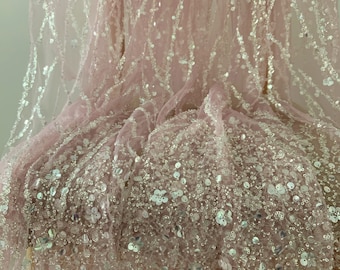 May include: Pink tulle fabric with silver sequins and beads. The fabric has a delicate, shimmering look.