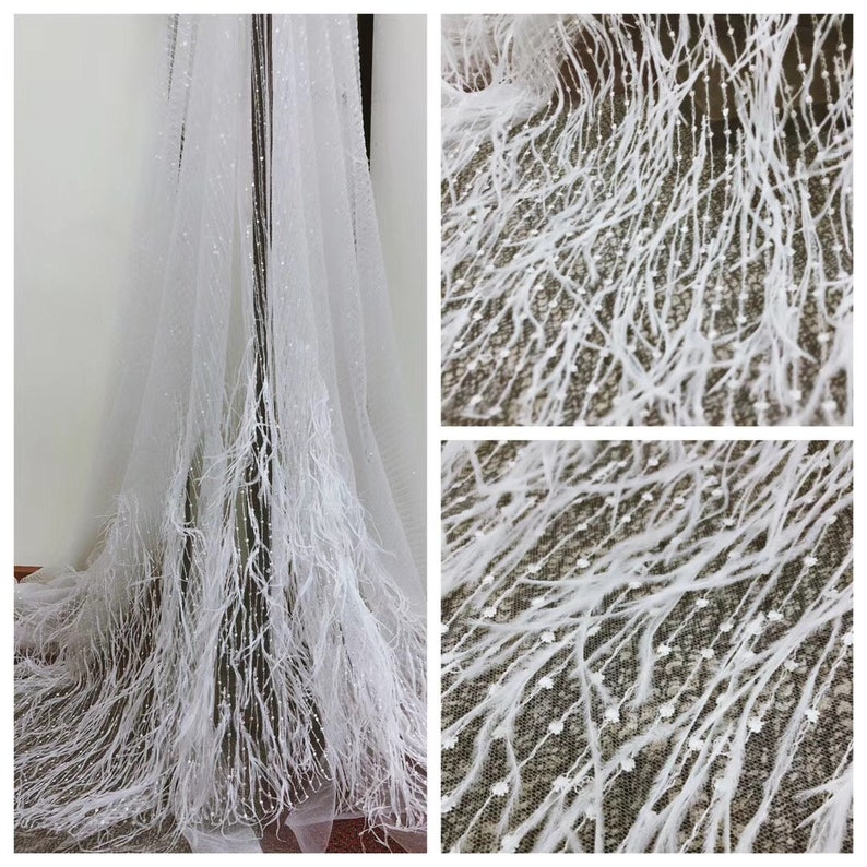 May include: White tulle fabric with a delicate feather trim and small white sequins. The fabric is sheer and has a soft, flowing texture.