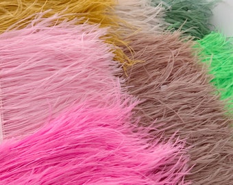May include: Assortment of colorful ostrich feather trim in various colors including pink, yellow, green, and brown. The feathers are soft and fluffy, perfect for adding a touch of elegance to any project.
