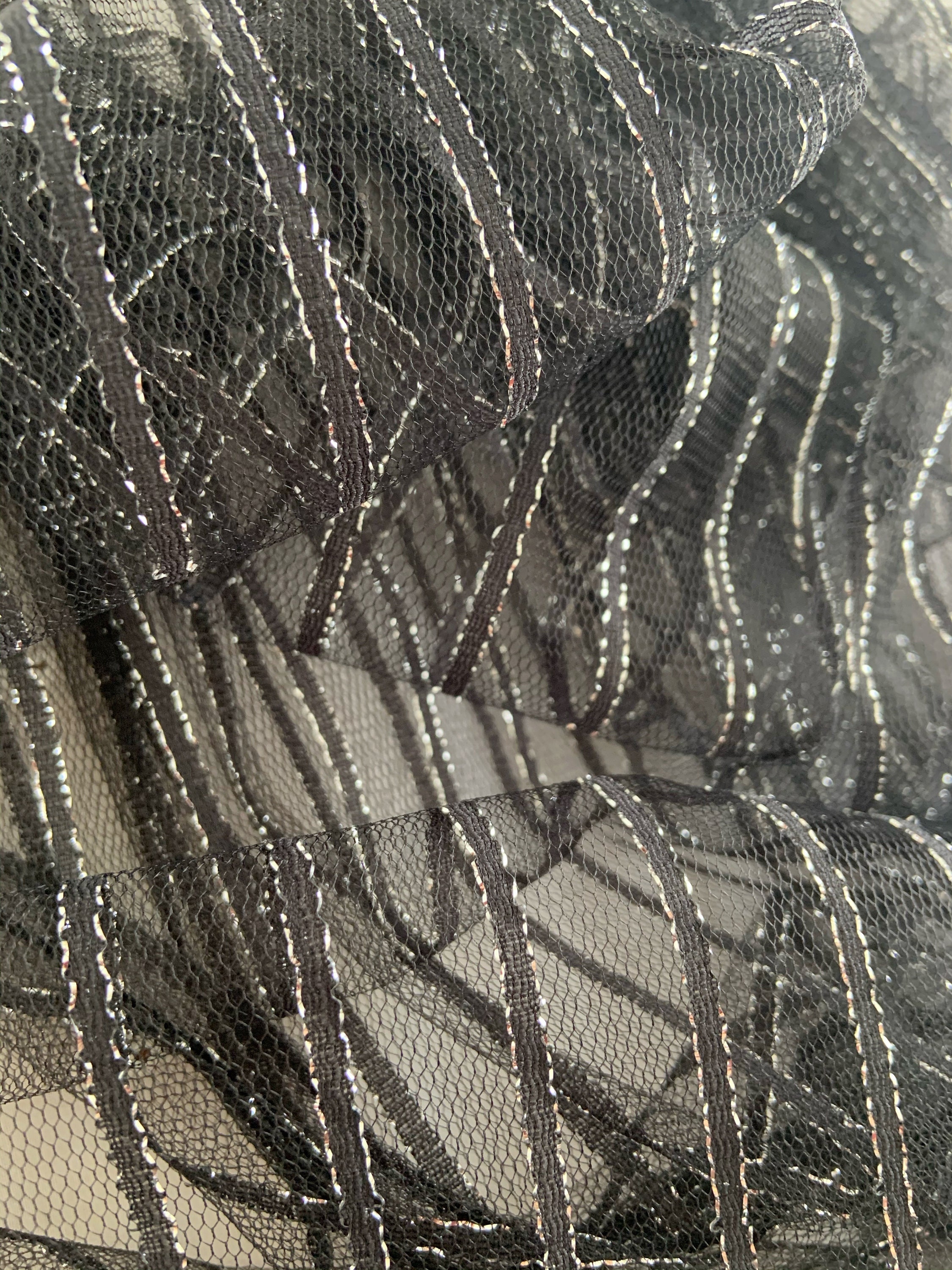 Tejido de tul negro con líneas de paralle plateado, para traje