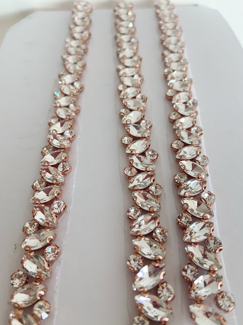 Puede incluir: Tres hileras de ribete de cristal de strass transparente con engastes de oro rosa. El ribete est&aacute; dise&ntilde;ado en un patr&oacute;n repetitivo de cristales en forma de marquesa.