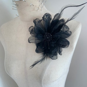 Schwarze Blumenapplikation mit Feder für das Kopfschmuckstück eines couture Hutmacher-Tanzes