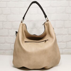 Peut inclure: Un sac hobo beige avec une poign&eacute;e et des bordures noires. Le sac poss&egrave;de une poche zipp&eacute;e &agrave; l'avant et un int&eacute;rieur spacieux. Fabriqu&eacute; dans un mat&eacute;riau doux et textur&eacute;, il est adapt&eacute; &agrave; un usage quotidien.