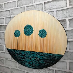 May include: A round wooden canvas painting with a teal blue water scene at the bottom and four teal blue trees in a row across the middle. The background is a light brown gradient.