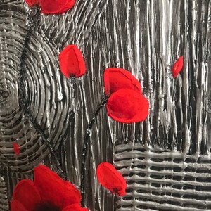 May include: Close-up of a textured artwork featuring bright red poppy flowers against a silver and gray background. The painting has a raised, three-dimensional effect, with visible brushstrokes and a textured surface.