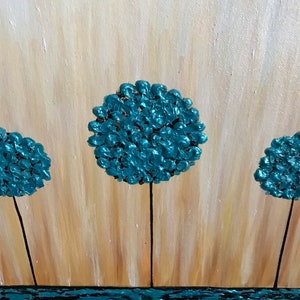May include: Abstract painting of three teal blue trees with black trunks against a light brown background. The trees are stylized and resemble round, fluffy clouds. The bottom of the painting features a teal blue wavy line representing water.
