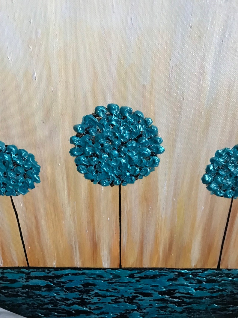 May include: Abstract painting of three teal blue trees with black trunks against a light brown background. The trees are stylized and resemble round, fluffy clouds. The bottom of the painting features a teal blue wavy line representing water.