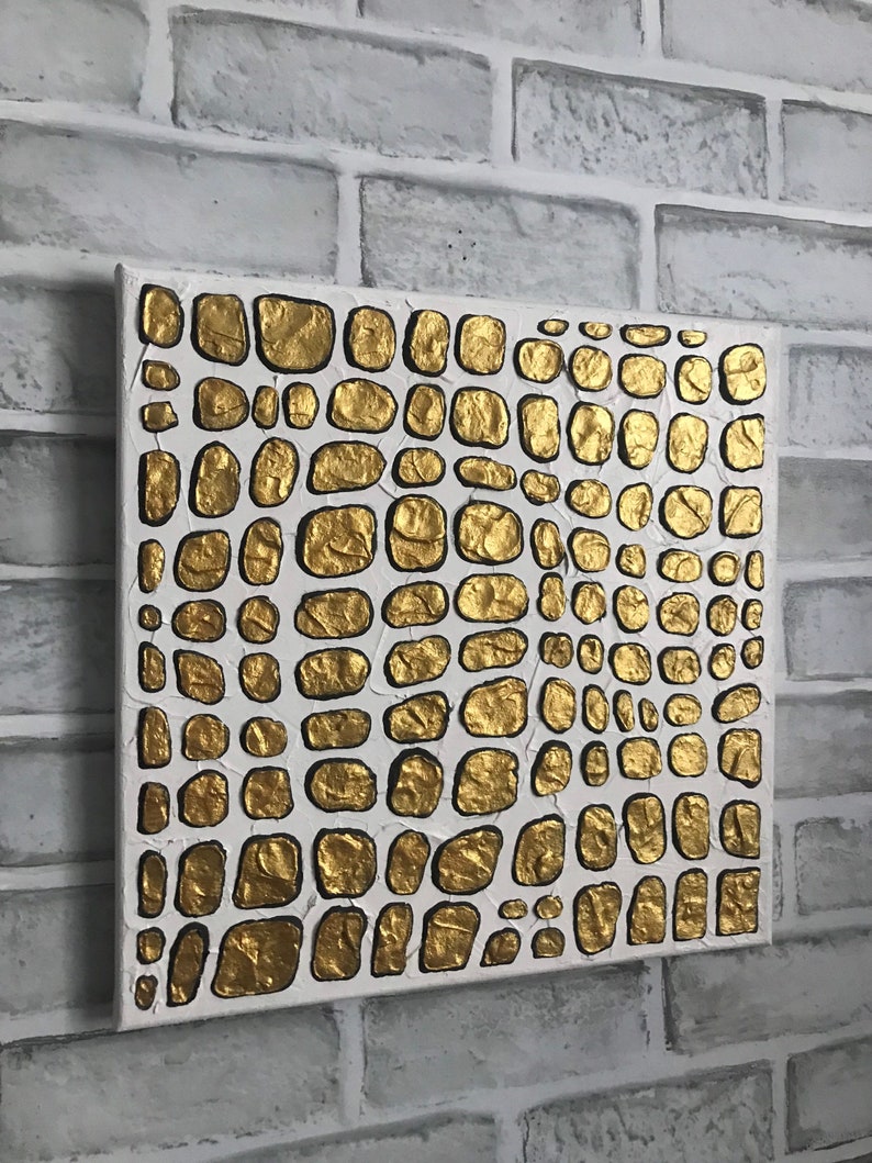 May include: Abstract painting on canvas with a textured gold and white design. The gold paint is raised and creates a pattern of overlapping circles.