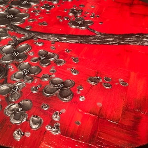May include: A red and silver abstract painting featuring a stylized tree with black flowers. The background is a textured red with a silver metallic sheen.