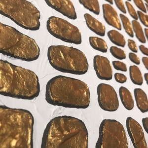 May include: A white canvas with a pattern of gold painted ovals. The ovals are outlined in black and have a textured look.