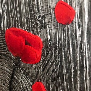 May include: Abstract textured artwork with a black and silver background. Several bright red, petal-shaped elements are scattered across the surface, creating a striking contrast. The piece has a rough, tactile quality.