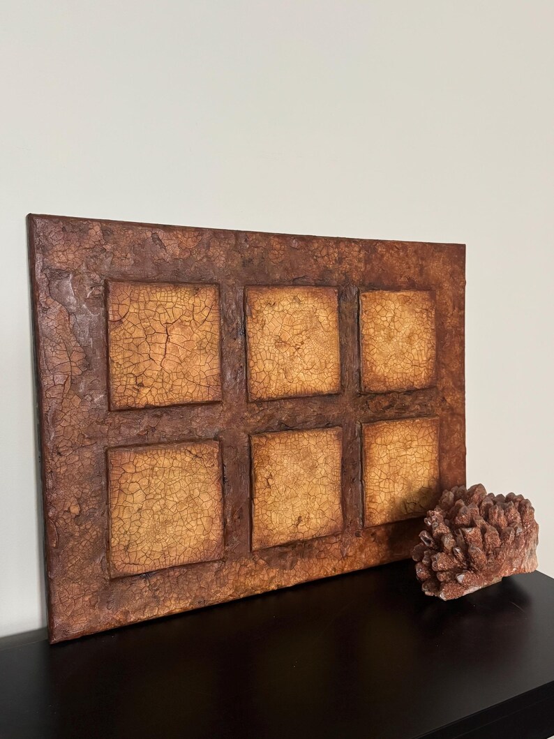 K&ouml;nnte beinhalten: Ein rechteckiges Wandbild mit rustikalem, strukturiertem Design. Das St&uuml;ck besteht aus sechs Quadraten, jedes mit einem anderen Muster aus Rissen und Linien. Die Quadrate sind von einem braunen Rahmen umgeben.