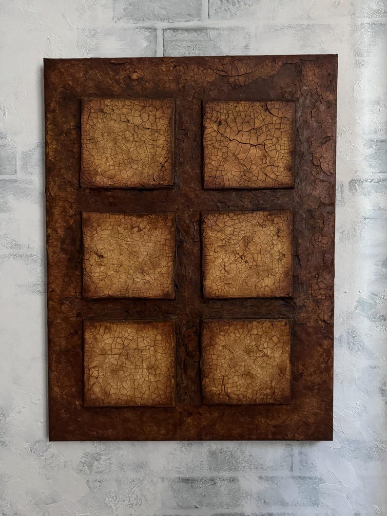 K&ouml;nnte beinhalten: Eine braune rechteckige Leinwand mit sechs quadratischen Paneelen. Jedes Paneel hat eine strukturierte, rissige Oberfl&auml;che in hellbrauner Farbe. Die Leinwand hat einen dunkelbraunen Rand.
