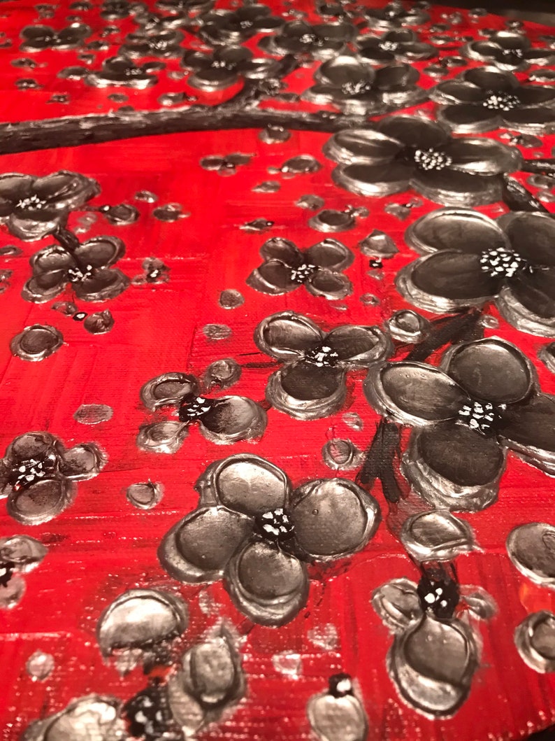 May include: A red background with a silver and black floral design. The flowers are painted in a textured style, giving the appearance of 3D.