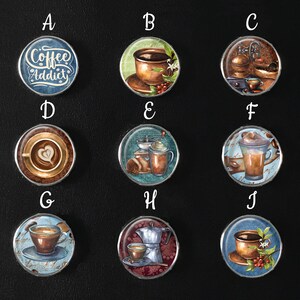 Könnte beinhalten: Zehn runde, silberfarbene, dekorative Metalluntersetzer mit verschiedenen Kaffeemotiven. Die Motive umfassen eine Kaffeetasse mit dem Text "Coffee Addict", eine Kaffeekanne, eine Kaffeemühle, einen Latte und einen Cappuccino.