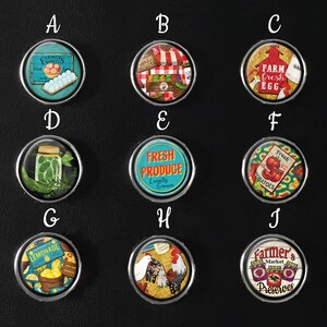 May include: Ten round, colourful magnets with various images related to a farm market. The images include fresh produce, eggs, jars of preserves, and a farmer's market stall.