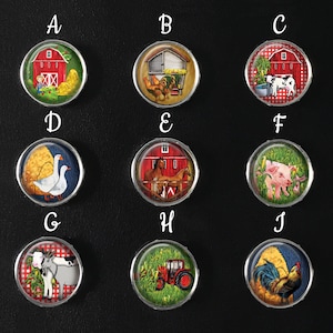 May include: Ten round, colourful, glass cabochons with silver settings, each featuring a different farm animal or scene. The cabochons are arranged in two rows of five, labelled A through J.