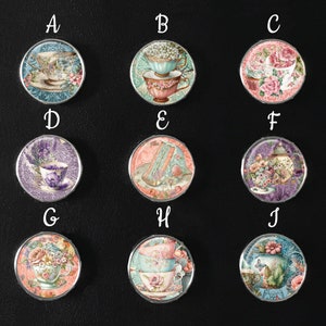 May include: Ten round, colorful, decorative, ceramic tiles with various images of teacups, flowers, and other vintage-inspired designs. Each tile has a letter from A to J printed above it.