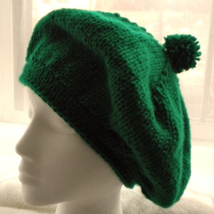 May include: A green knitted beret with a pom-pom on top.