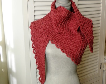 May include: A red crocheted shawl with a scalloped edge. The shawl is draped over a mannequin.
