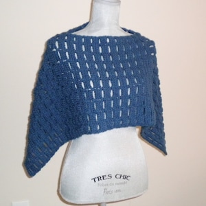 Könnte beinhalten: Ein blauer Häkel-Schal mit einem zarten Muster. Der Schal ist über eine weiße Schaufensterpuppe gelegt.