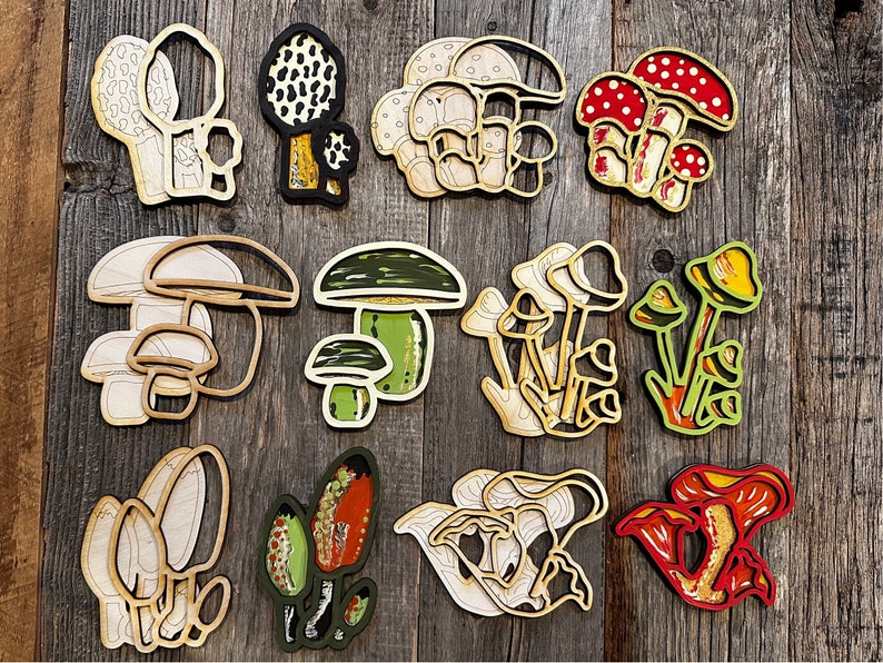 Op de afbeelding: Een set van 12 houten paddenstoelversieringen in verschillende vormen, maten en kleuren. De paddenstoelen zijn geschilderd in tinten bruin, wit, rood, groen en geel. Ze zijn perfect om een vleugje whimsy toe te voegen aan je interieur.