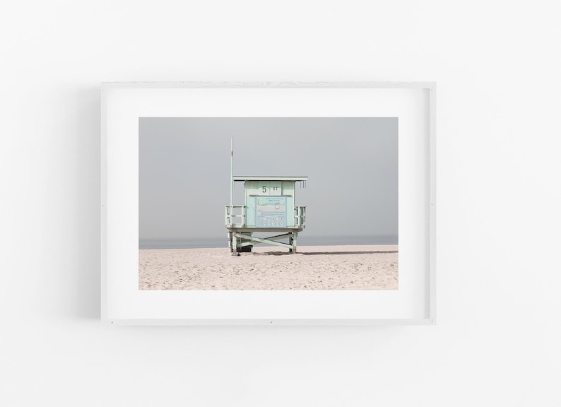 May include: A light blue lifeguard stand on a sandy beach with a cloudy sky in the background. The stand has a sign that reads "51 ST".
