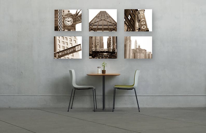 Puede incluir: Un conjunto de seis fotograf&iacute;as en blanco y negro de paisajes urbanos de Chicago, incluyendo el r&iacute;o Chicago, el Wrigley Building y el puente Michigan Avenue. Las fotos se muestran en una pared sobre una mesa peque&ntilde;a y dos sillas.