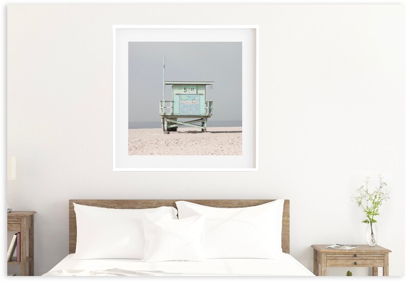 May include: A light blue lifeguard stand on a sandy beach with a gray sky in the background.
