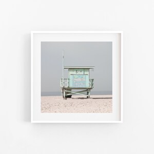 May include: A light blue lifeguard stand with a white roof and a sign that says "5-91" on a sandy beach.