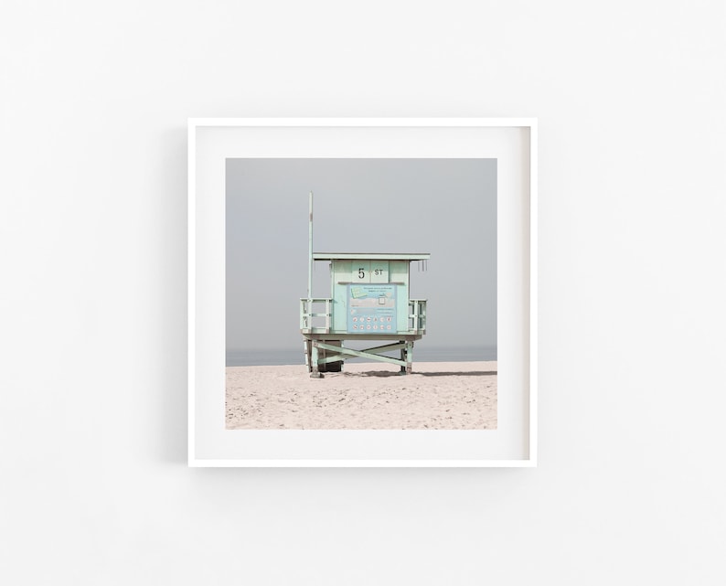 May include: A light blue lifeguard stand with a white roof and a sign that says "5-91" on a sandy beach.