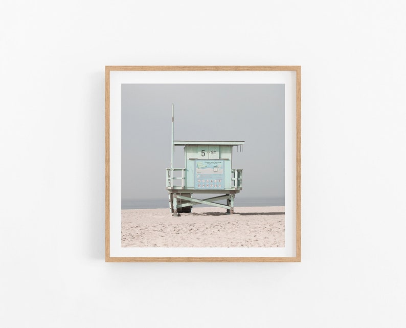 May include: A light blue lifeguard stand with a white sign that reads "5 ST" on a sandy beach.