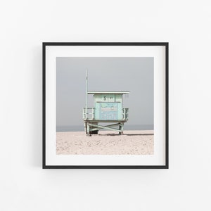 May include: A light green lifeguard stand with a white roof and a sign that reads "5 31" on a sandy beach.