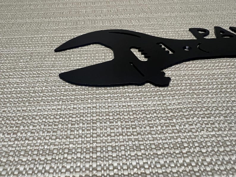 May include: Black metal wrench shaped like a guitar with the word "Papa" cut out of the metal.