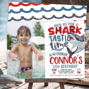 May include: A birthday party invitation featuring a photo of a child in a pool. The invitation has a red, white, and blue wave design at the top. The text reads "Join us for a Shark Tastic Time" and includes party details.