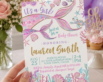 May include: A baby shower invitation with a mermaid theme. The invitation features the text "It's a Girl!" and "Join us for a Baby Shower". The invitation includes the honoree's name, date, time, and RSVP information. The invitation is decorated with mermaid tails, seashells, and seahorses.