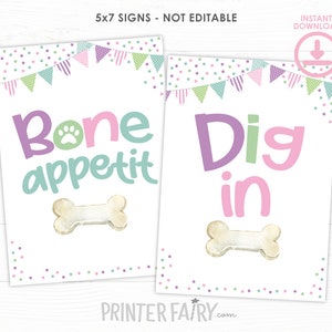 May include: Two printable 5x7 inch signs with a dog bone theme. The first sign says "Bone Appetit" with a paw print and a white bone. The second sign says "Dig in" with a white bone.